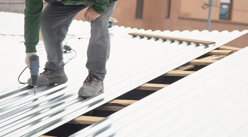 Roofer installing corrugated metal roof panels – Dallas Roofings