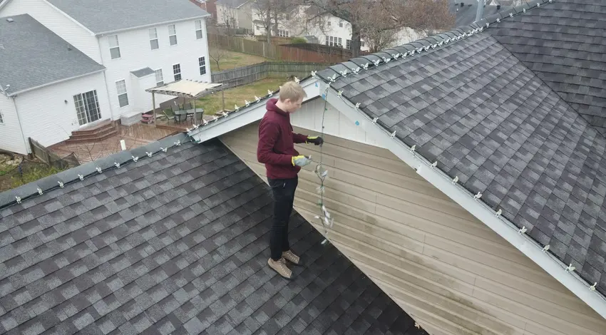 Worker repairing siding near shingle roof – Dallas Roofings