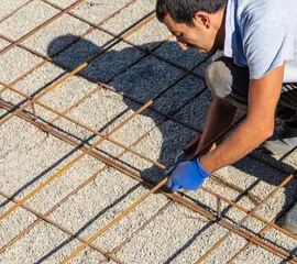 Worker preparing rebar framework for roofing base – Dallas Roofings