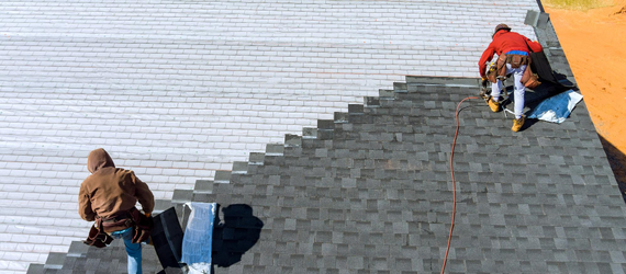 Roofers installing asphalt shingles on large roof – Dallas Roofings
