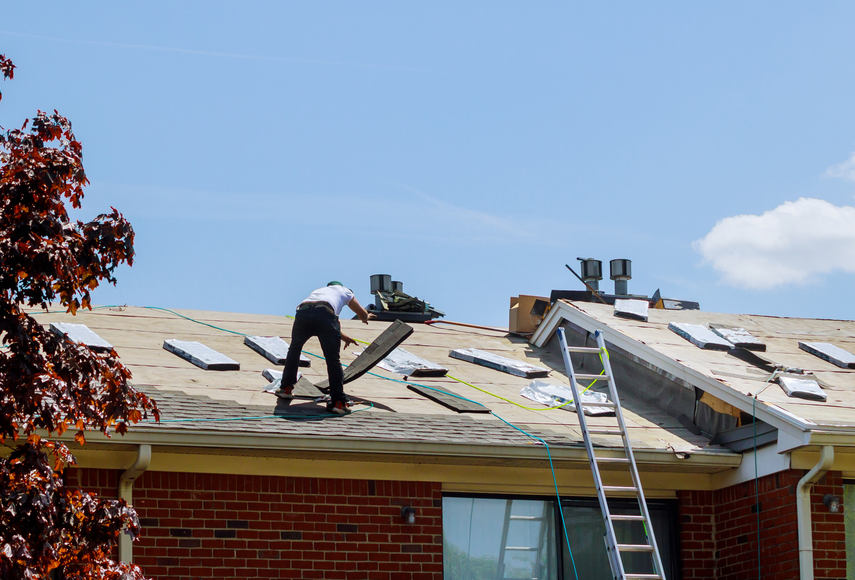 Roofer installing new shingles on residential roof – Dallas Roofings