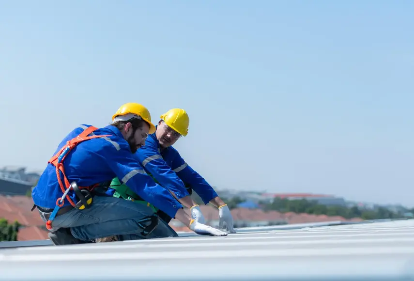 Roofers inspecting metal roof panels – Dallas Roofings